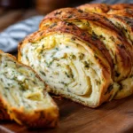 Garlic herb cheese filling spread on dough for swirled cheese bread